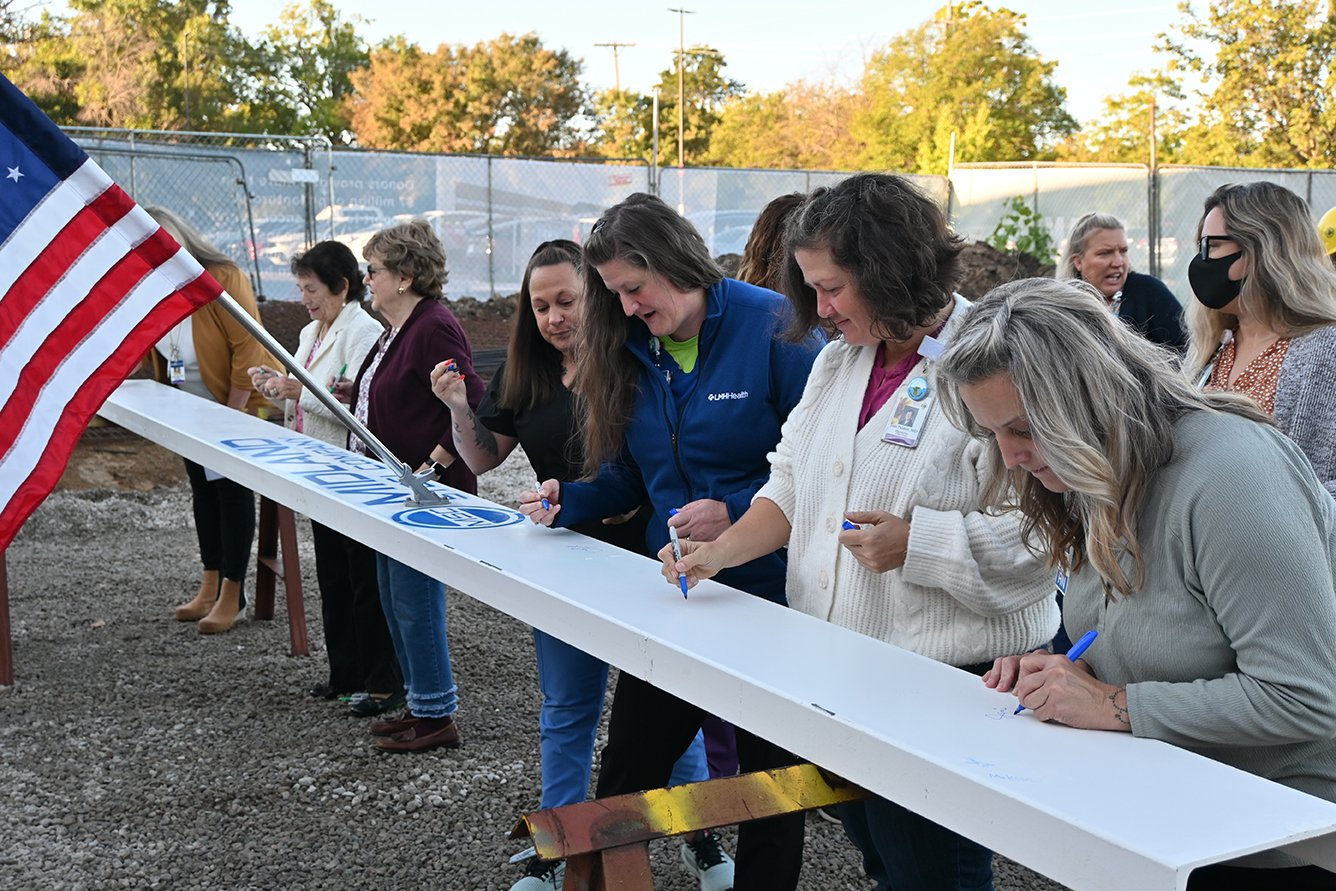 Donors and Cancer Center physicians and staff sign the beam before it becomes a permanent structure in the renovated and expanded LMH Health Cancer Center.
