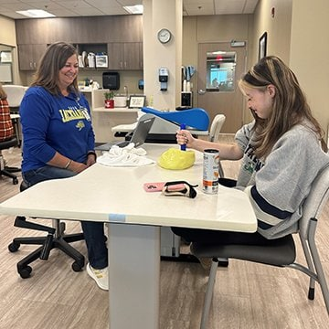 Kathy Randall looks on as Alex Gleason completes an exercise