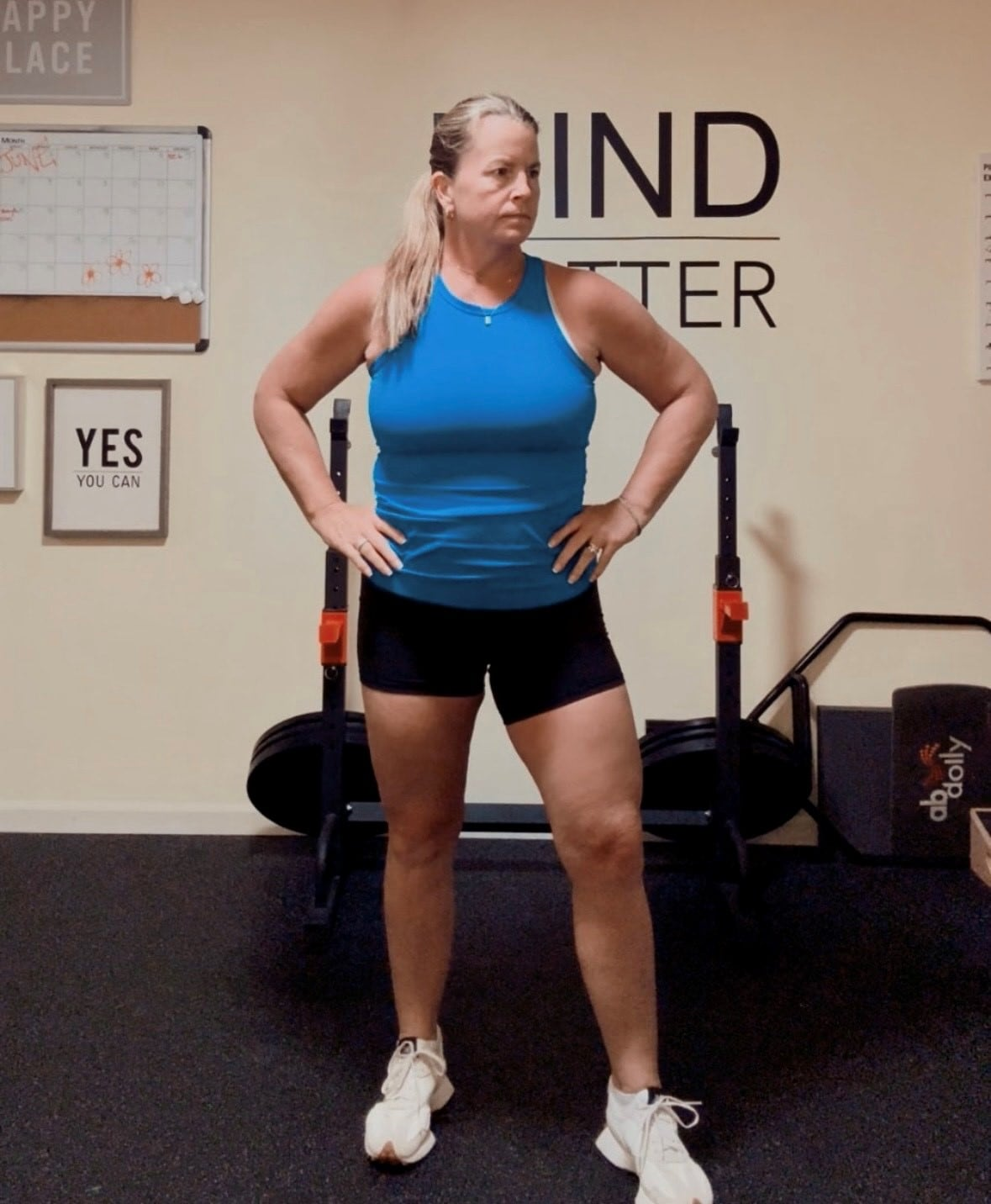 Tracey English stands in front of fitness equipment in her home gym