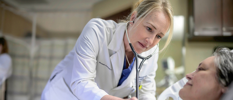 Dr. Elizabeth Guastello listens to a patient's heart
